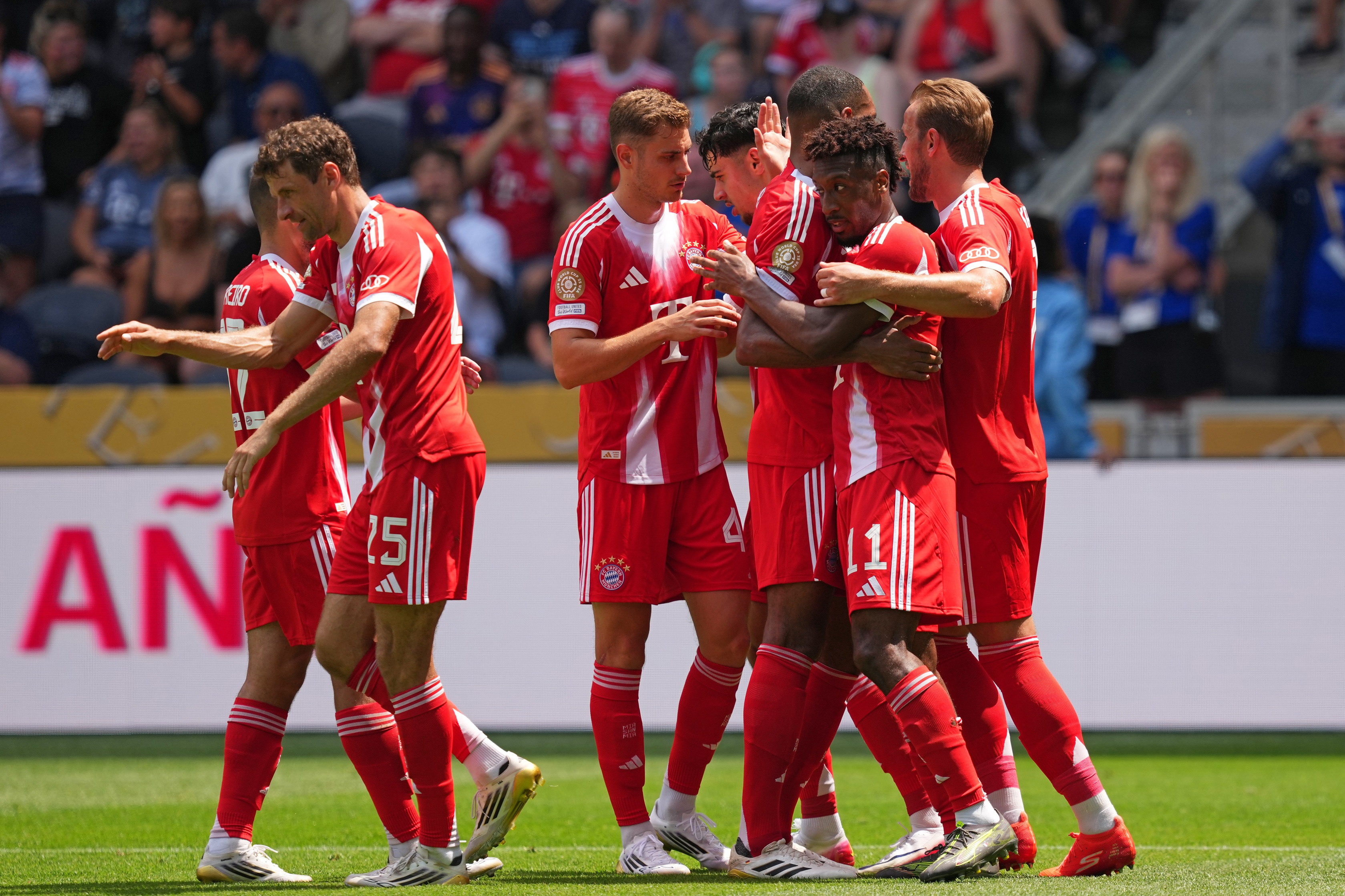 Kingsley Coman hugs Jonathan Tah during celebrations with Bayern players.