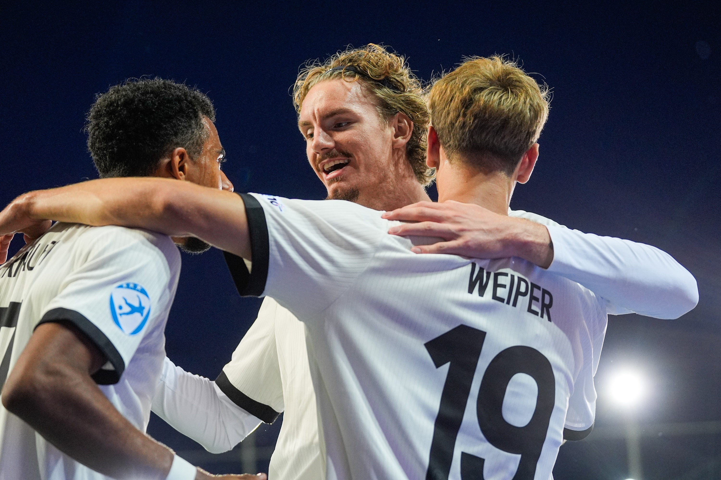 Nick Woltemade hugs two Germany U21s teammates.