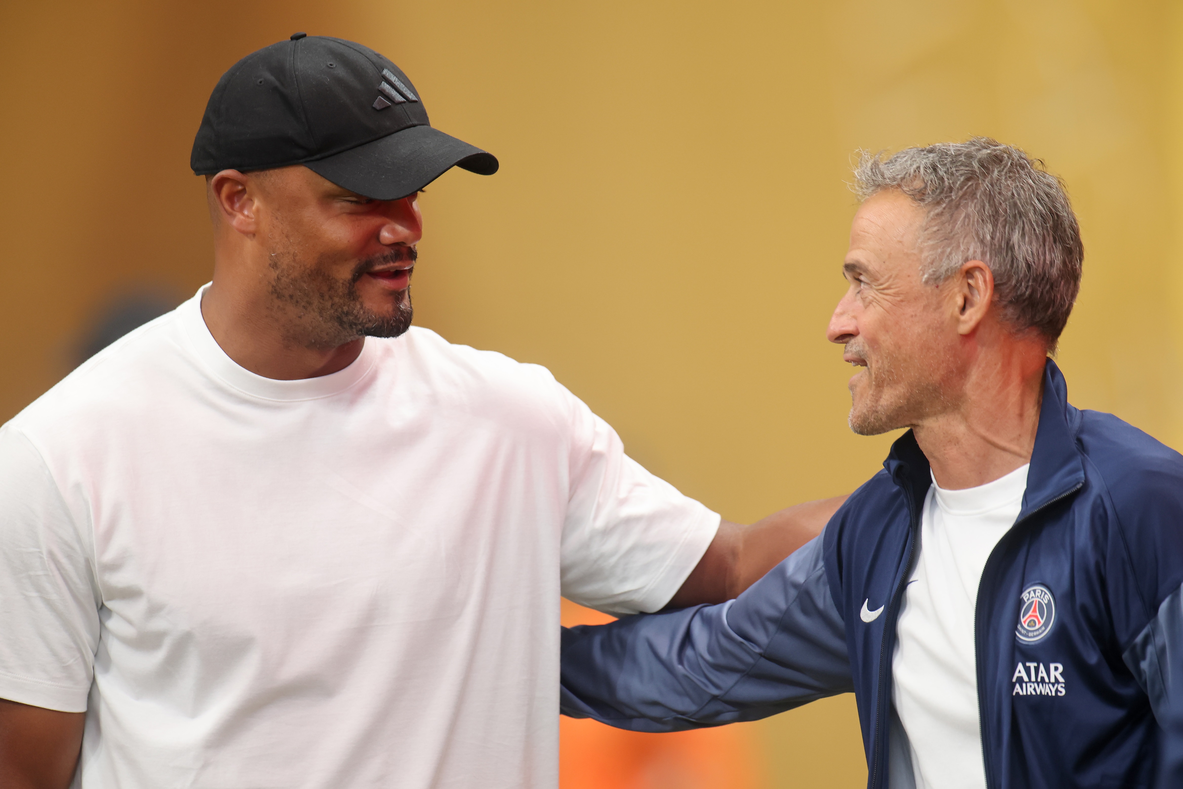 Vincent Kompany embraces PSG head coach Luis Enrique.