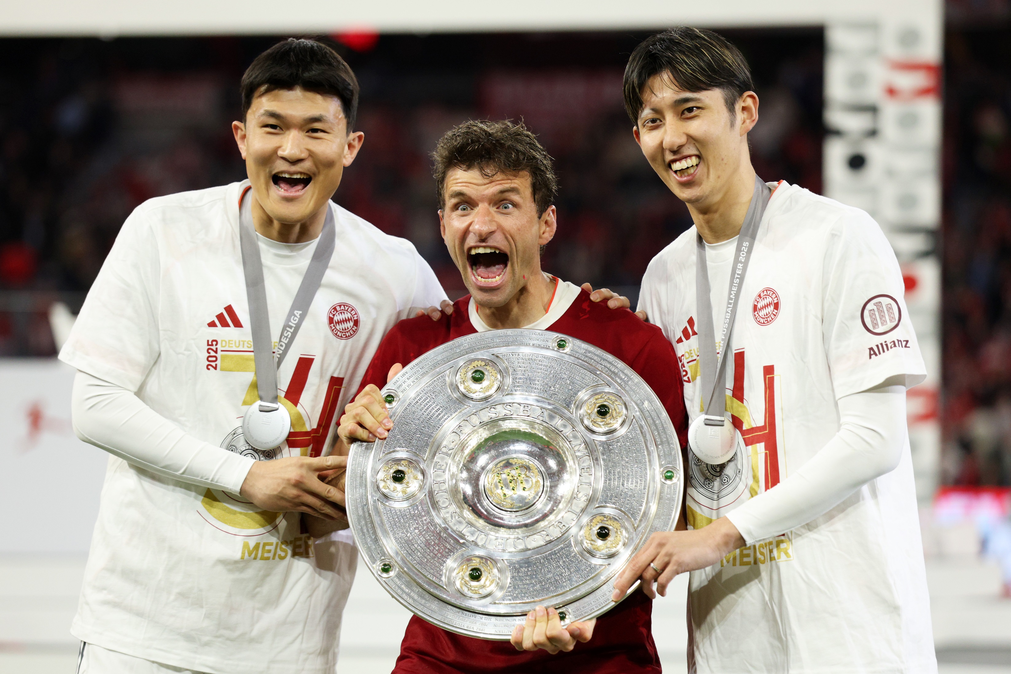 Kim Min-jae holds the Bundesliga trophy with Thomas Muller.