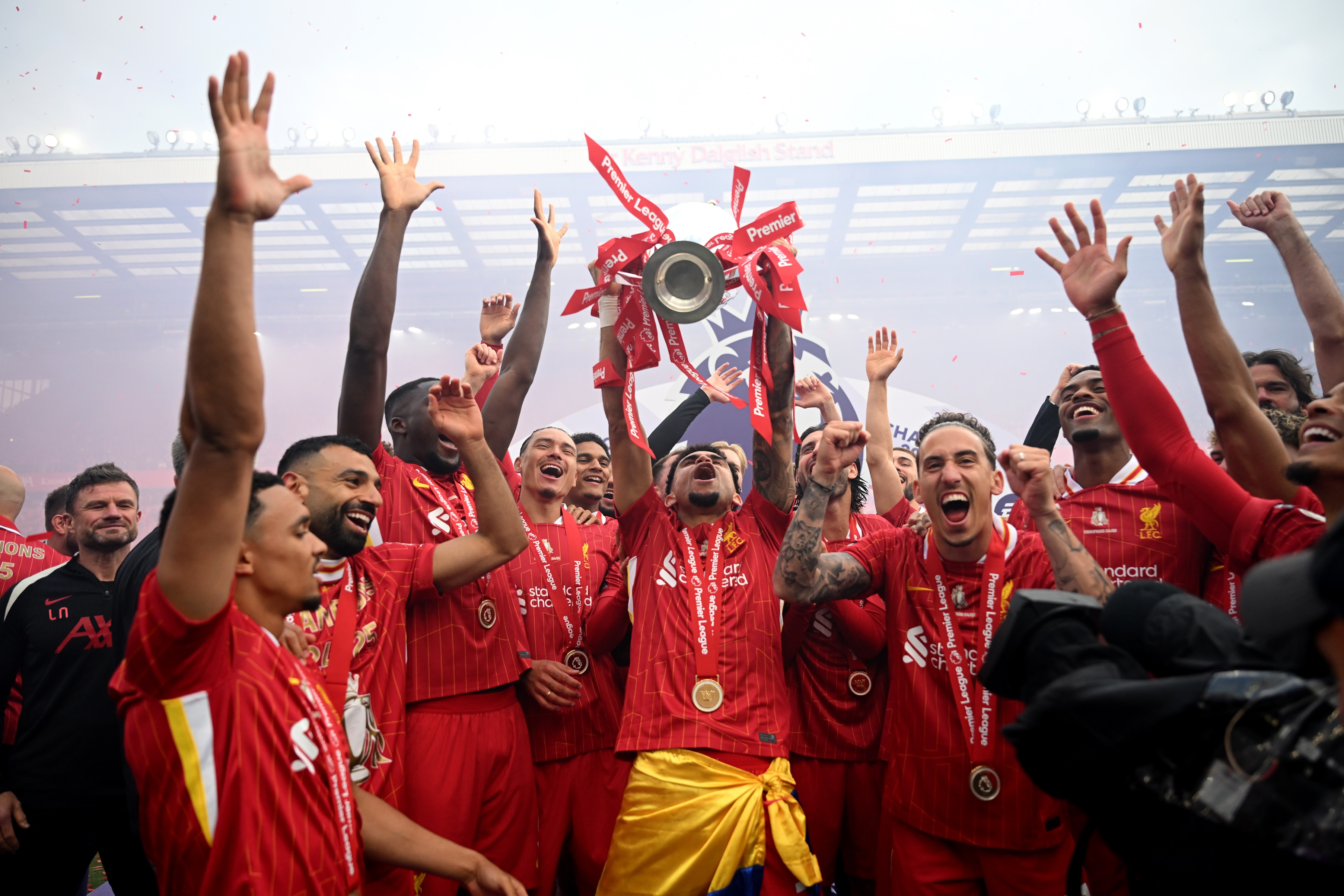 Luis Diaz lifts the Premier League trophy whilst surrounded by Liverpool players.