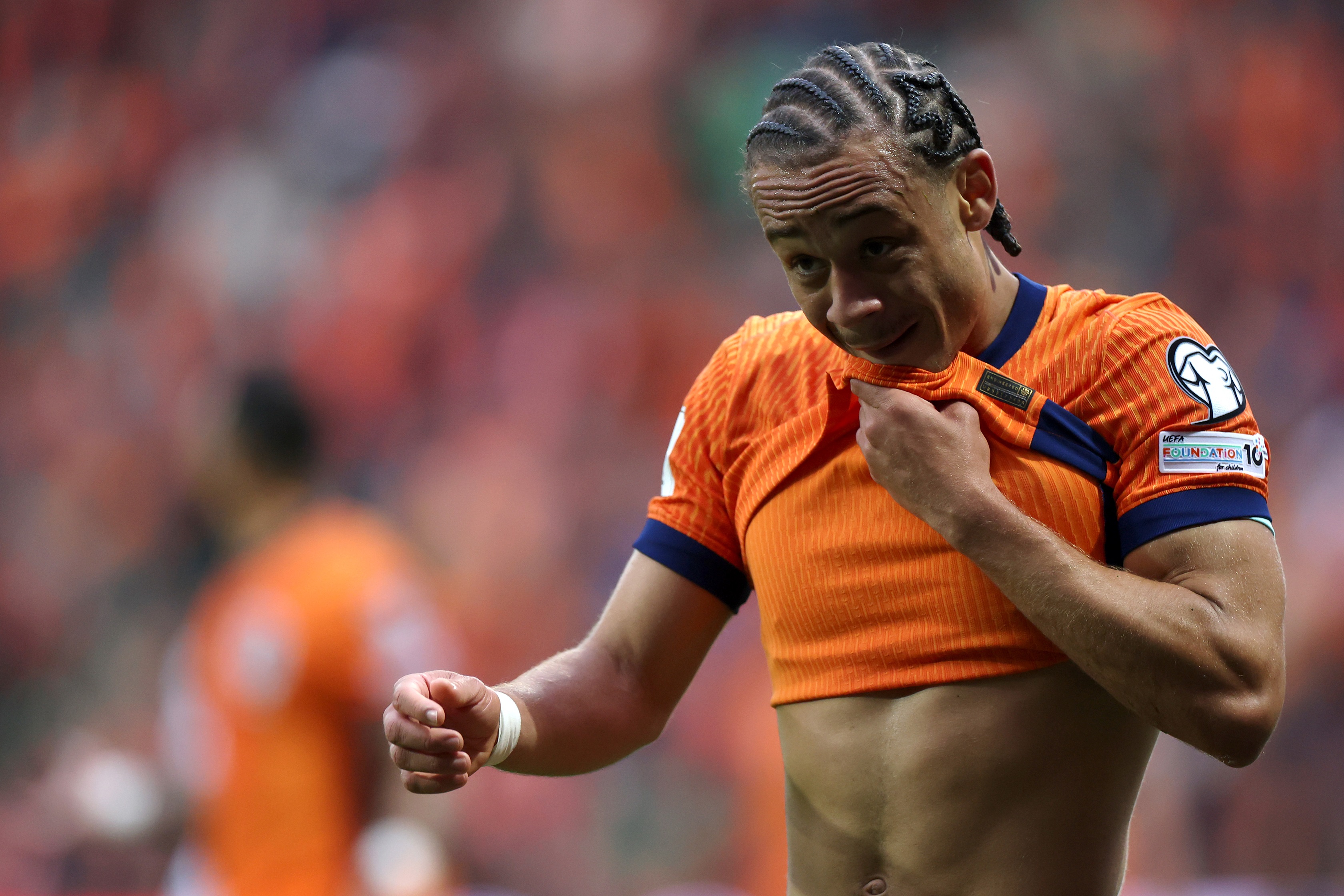 Xavi Simons lifts up his Netherlands shirt to reveal his abdomen.