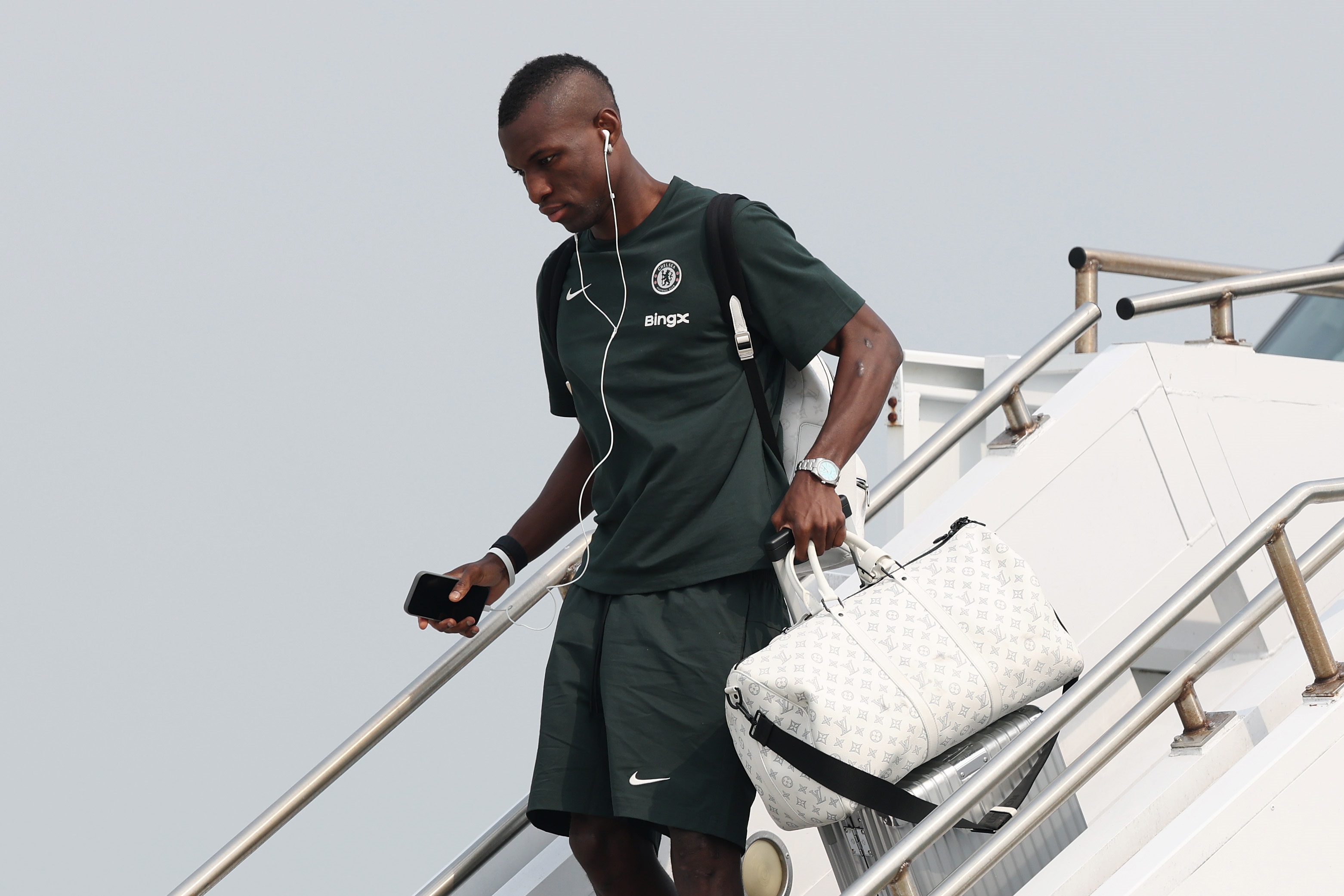 Nicolas Jackson walks down the plane stairs.