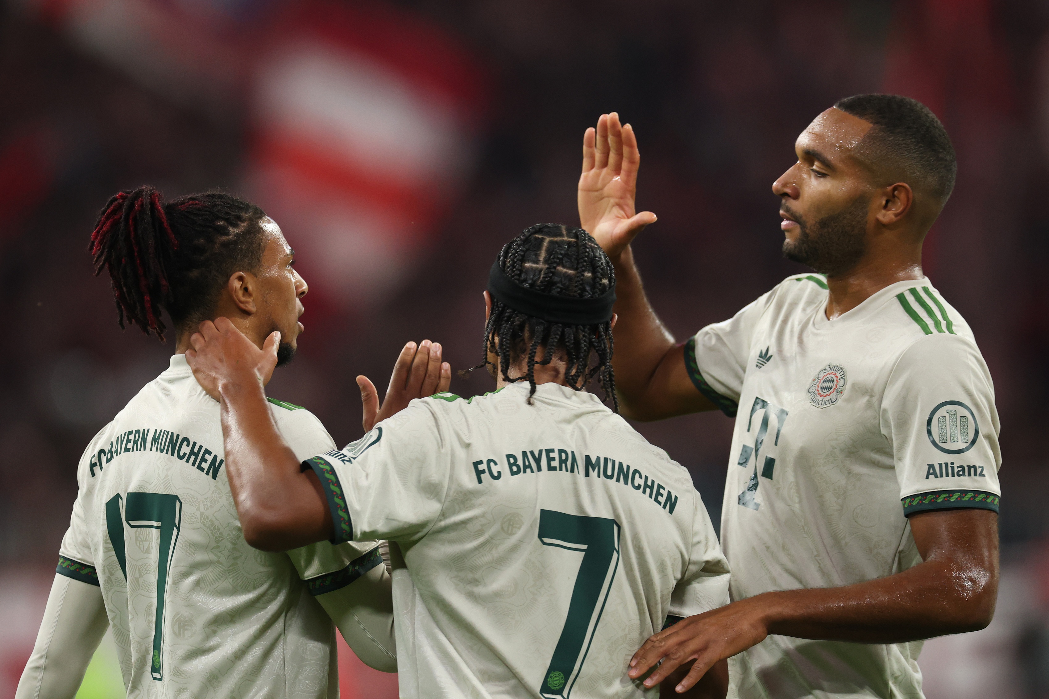Jonathan Tah high fives Michael Olise as Serge Gnabry celebrates.