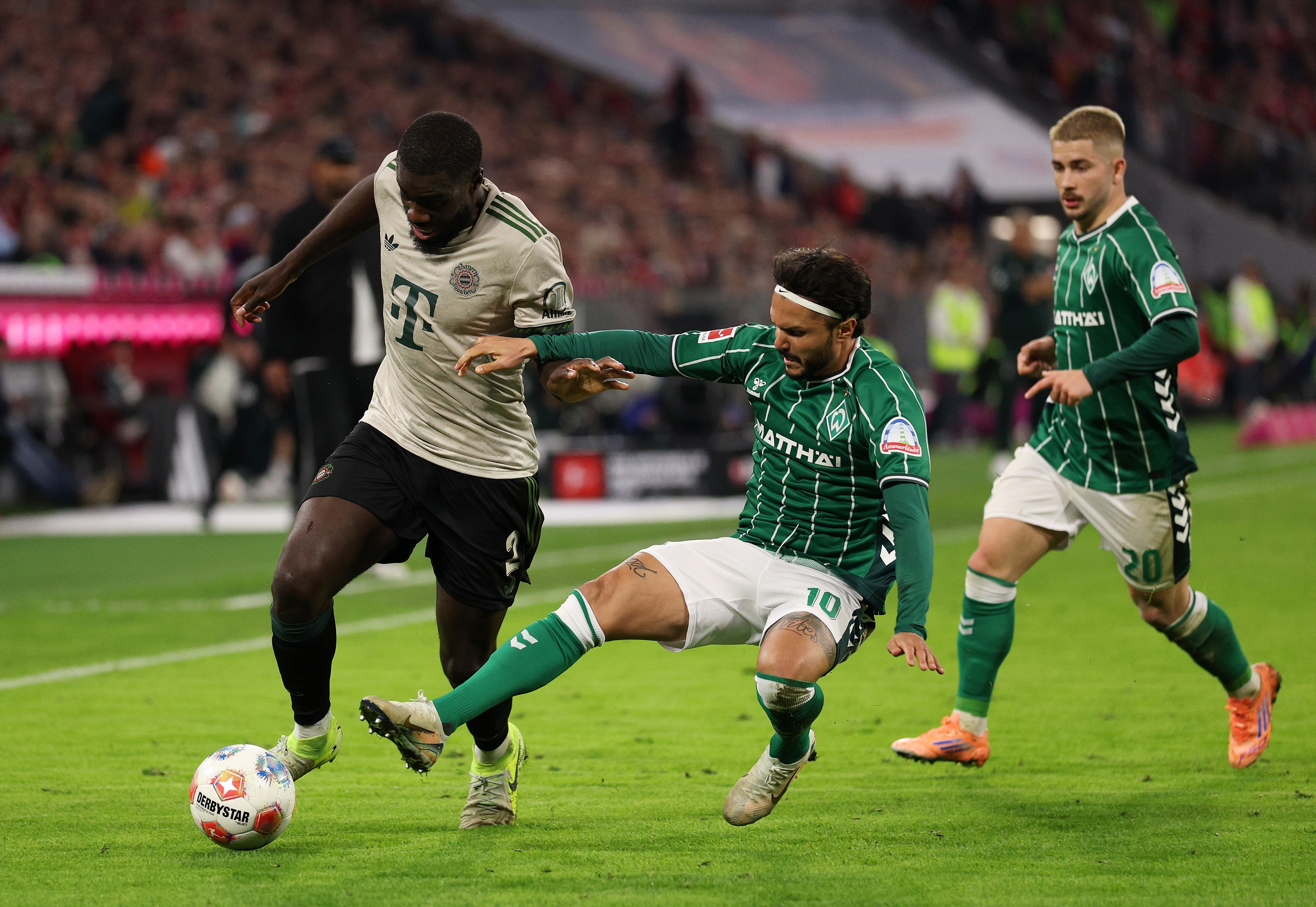 Dayot Upamecano dribbles with the ball as Werder Bremen player tries to tackle him.