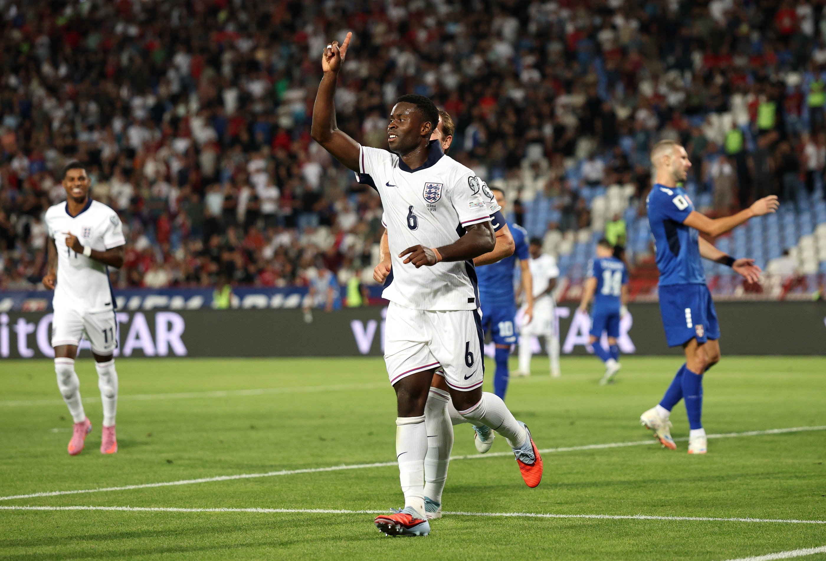Marc Guehi points up at the air during goal celebration.