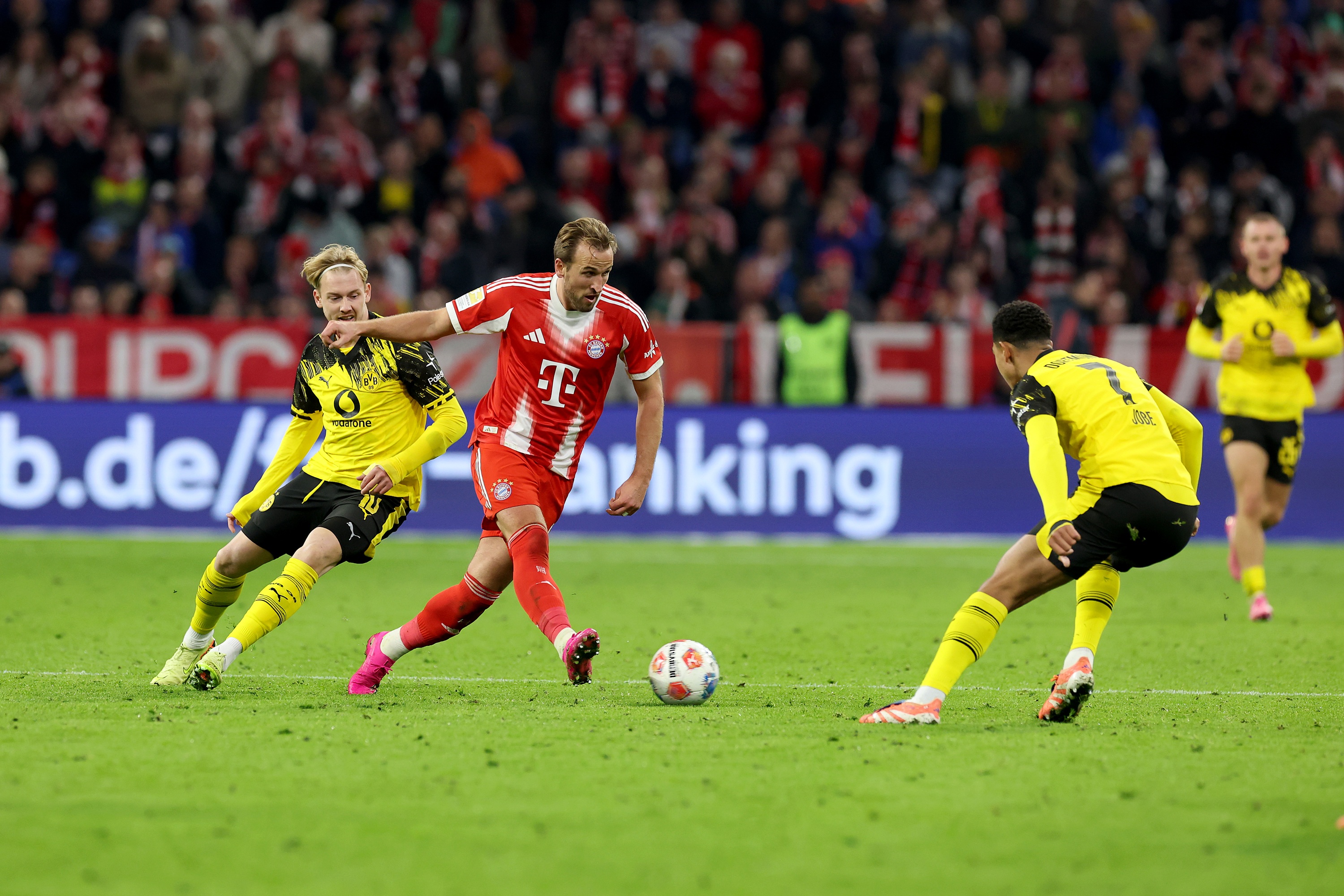 Harry Kane plays a pass whilst BVB players surround him.