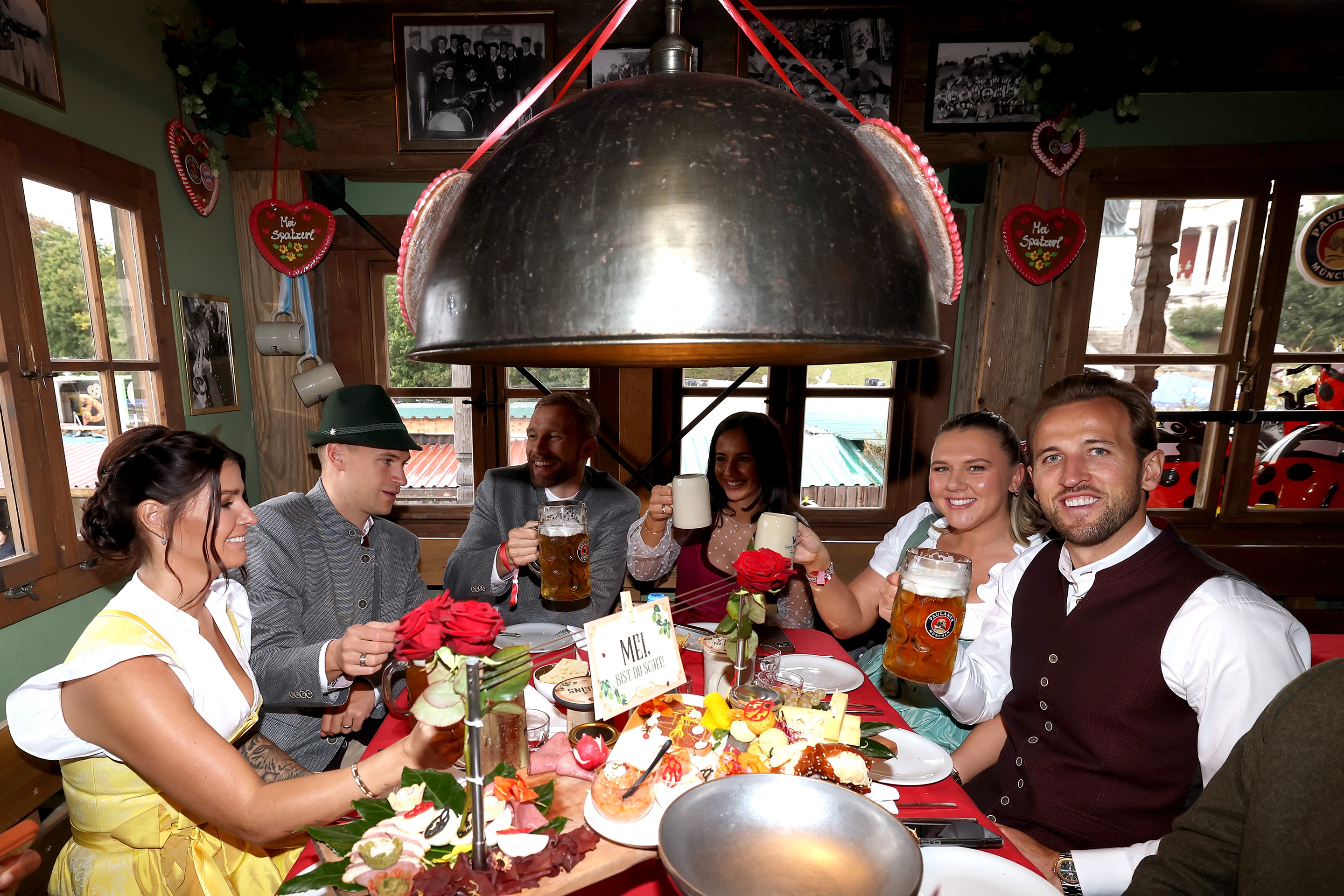 Harry Kane, Joshua Kimmich and Konrad Laimer hold up beer steins at Oktoberfest.