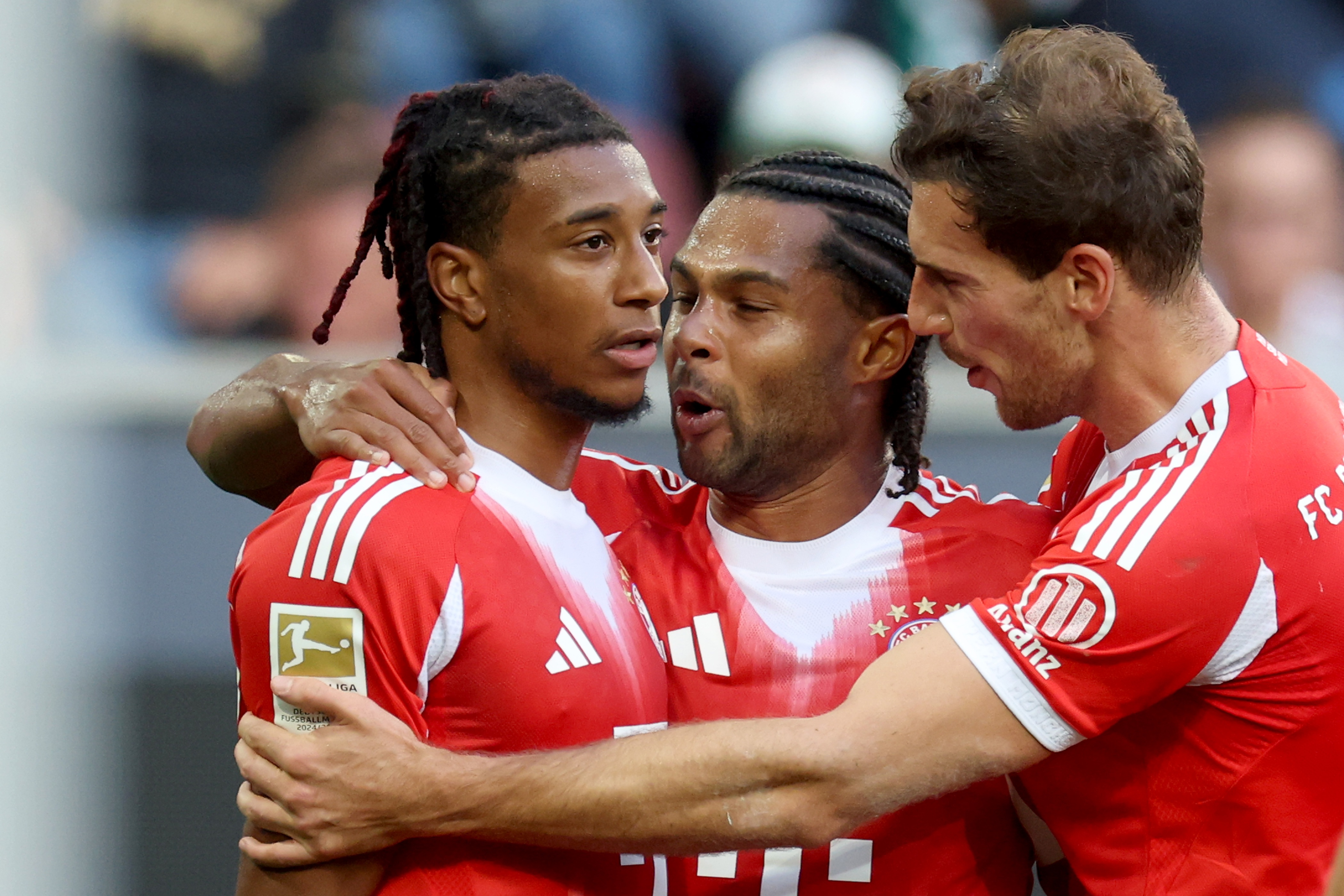 Serge Gnabry and Leon Goretzka hug Michael Olise.