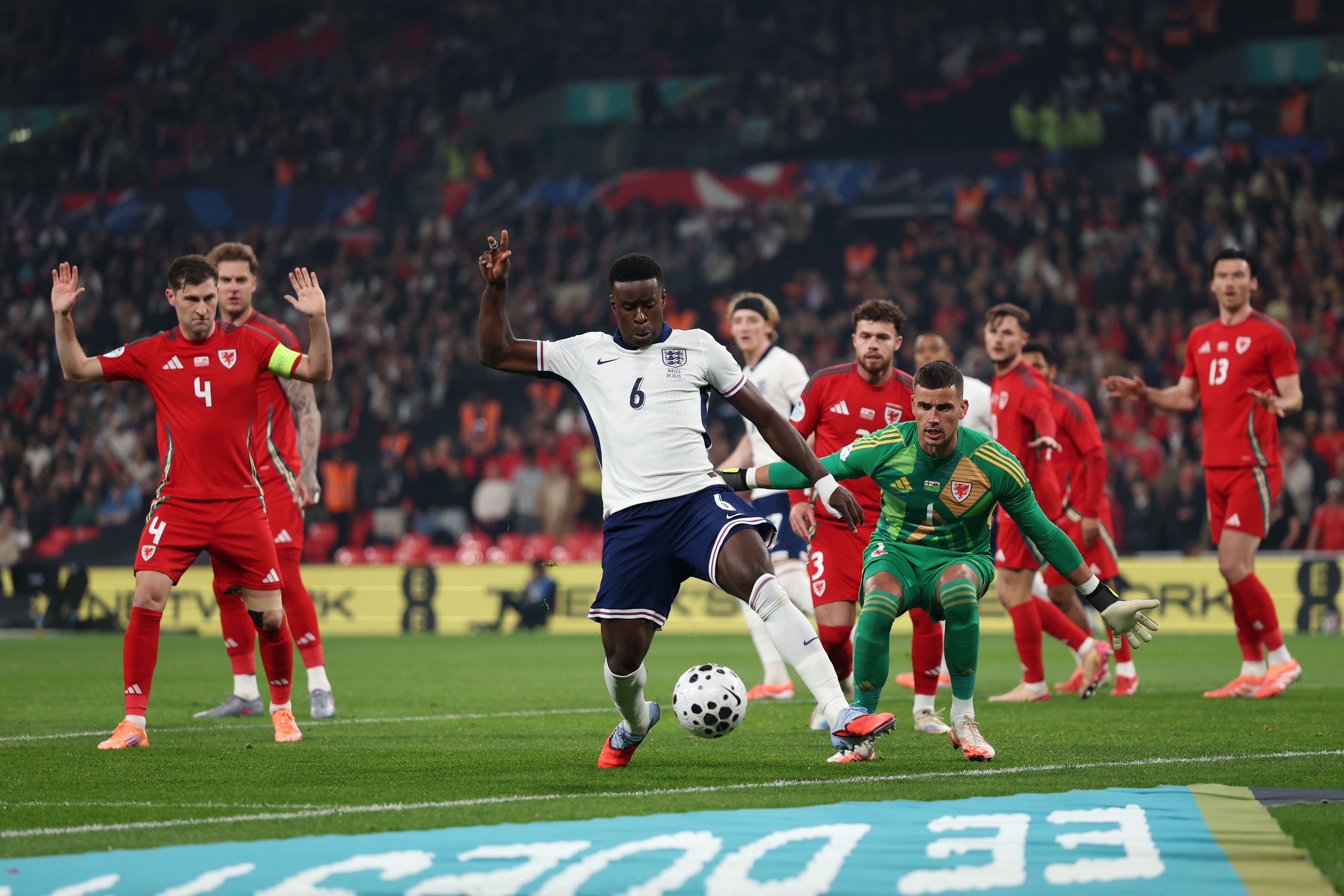 Marc Guehi tries to control the ball for England whilst surrounded by Wales players.