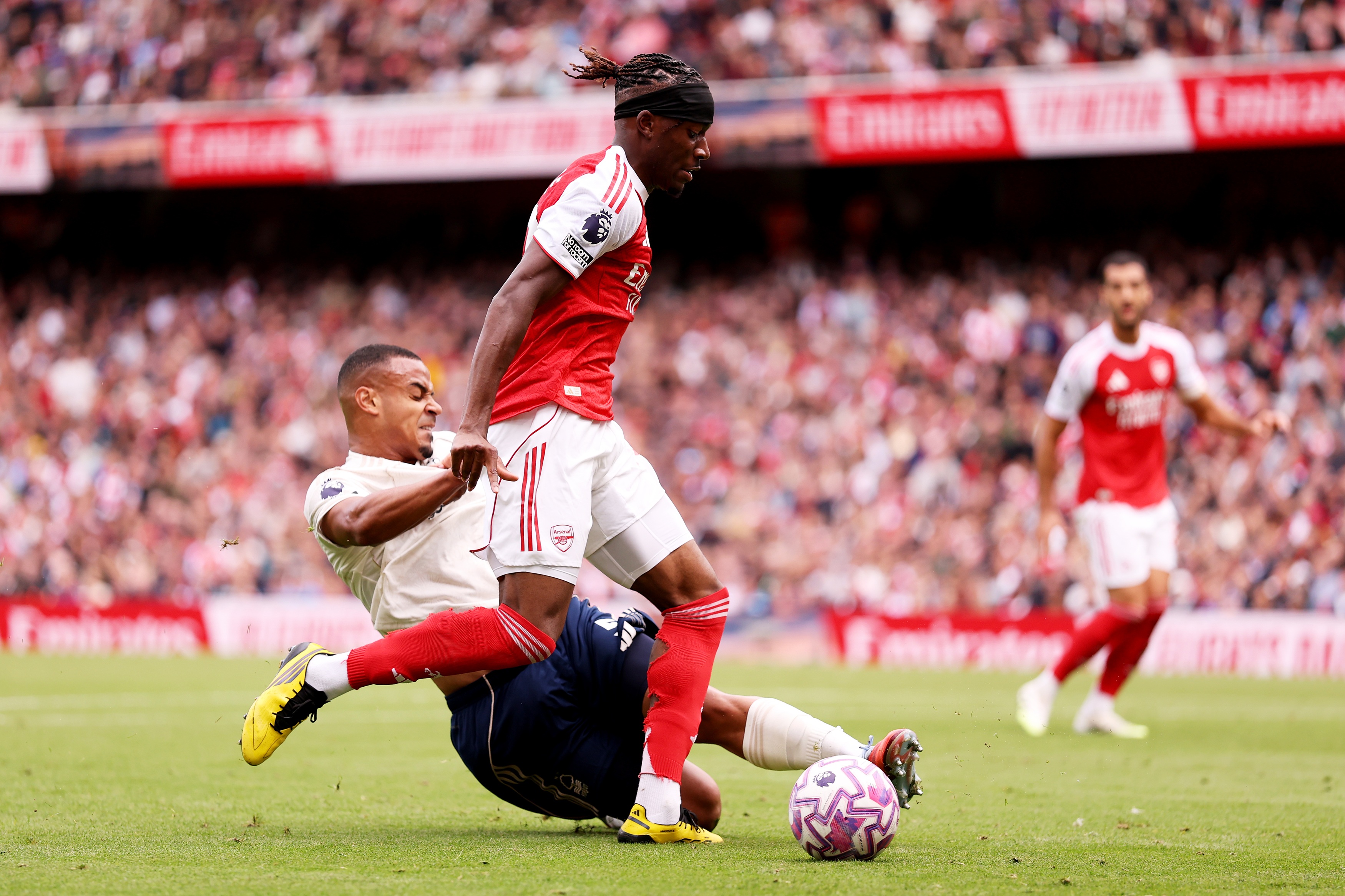 Murillo goes to ground to try to win ball from Noni Madueke.