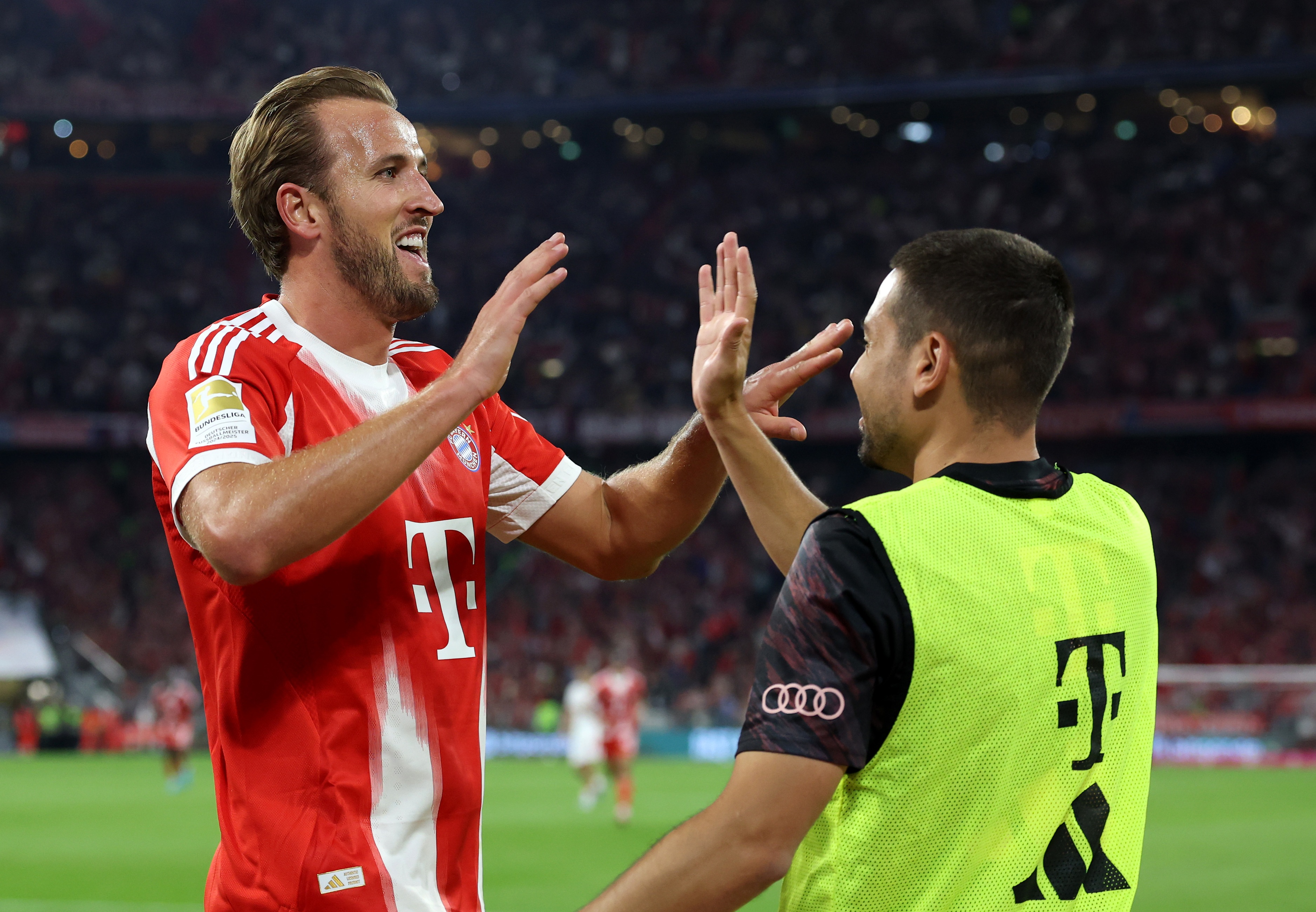 Raphael Gurreiro high-fives Harry Kane during Bayern game.
