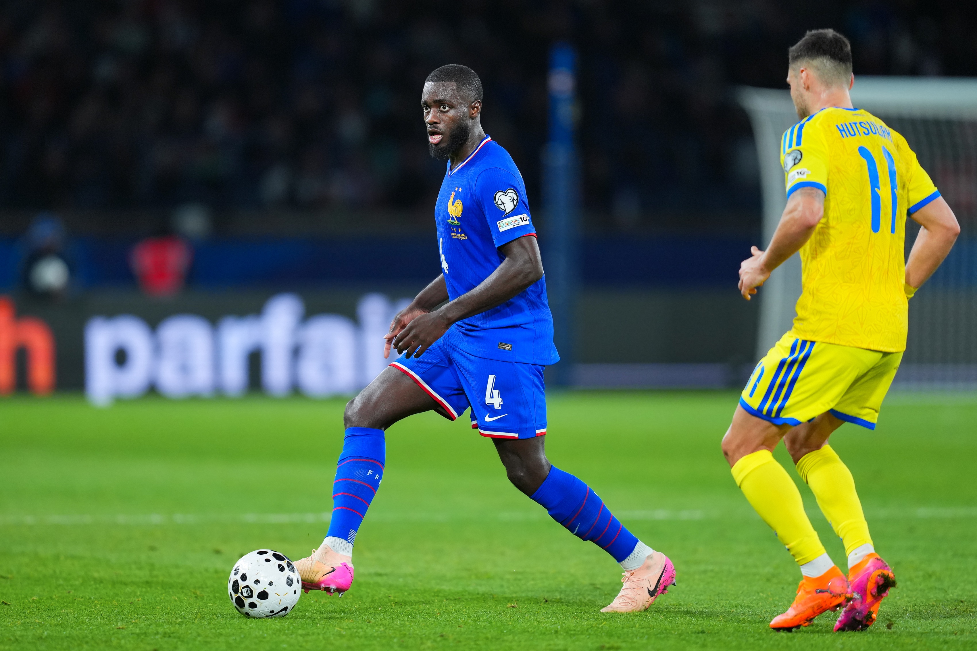 Dayot Upamecano dribbles with the ball while under pressure from Ukraine player.