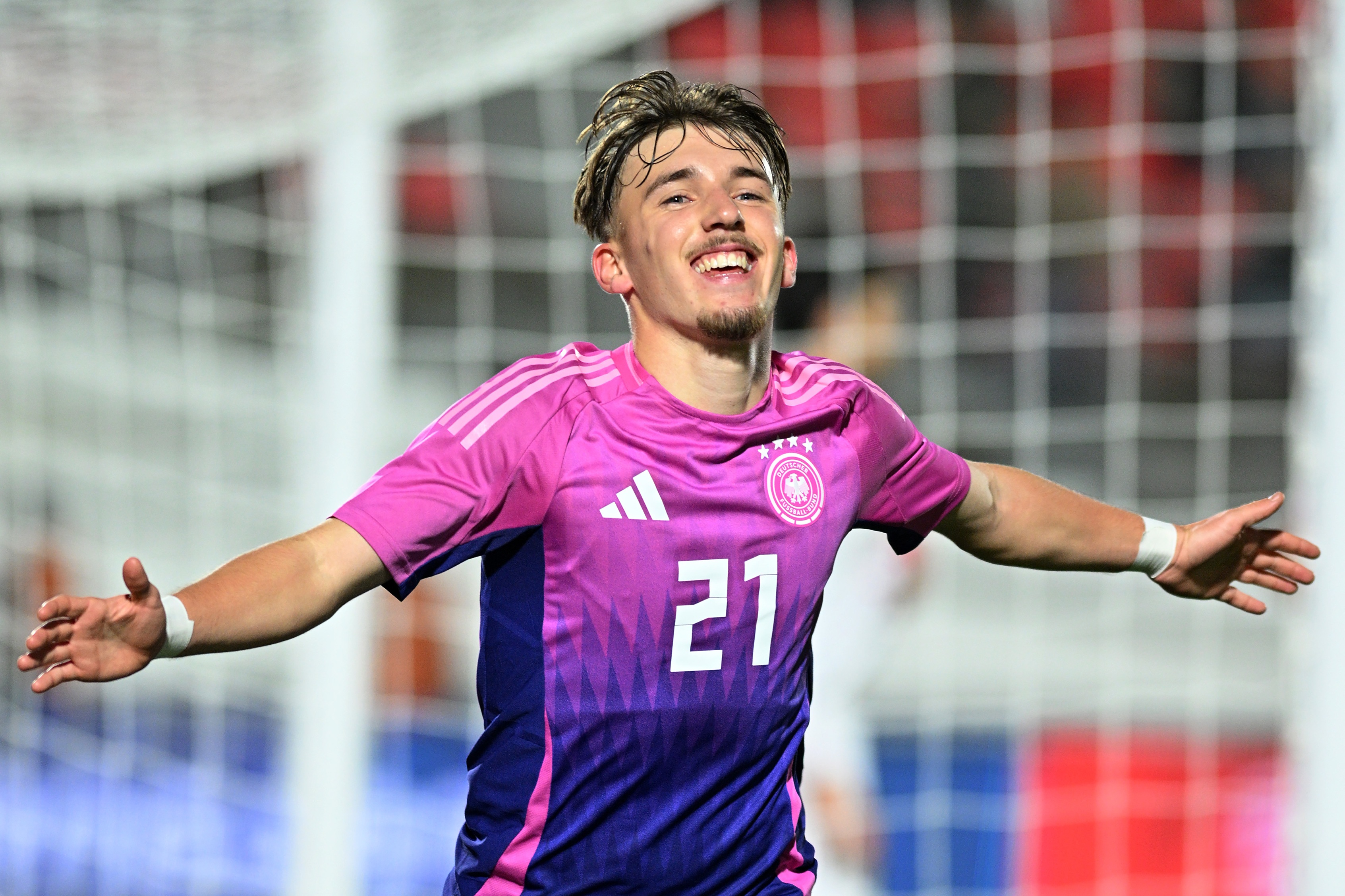 Lennart Karl holds his arms out wide in celebration.