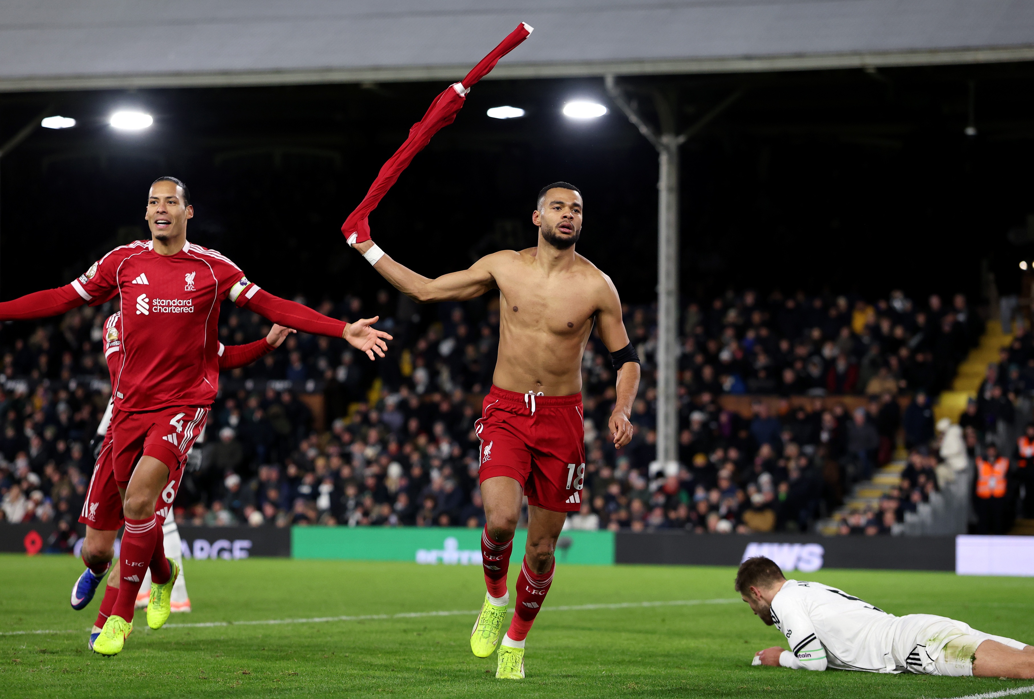 Cody Gakpo swings his Liverpool shirt around in celebration.