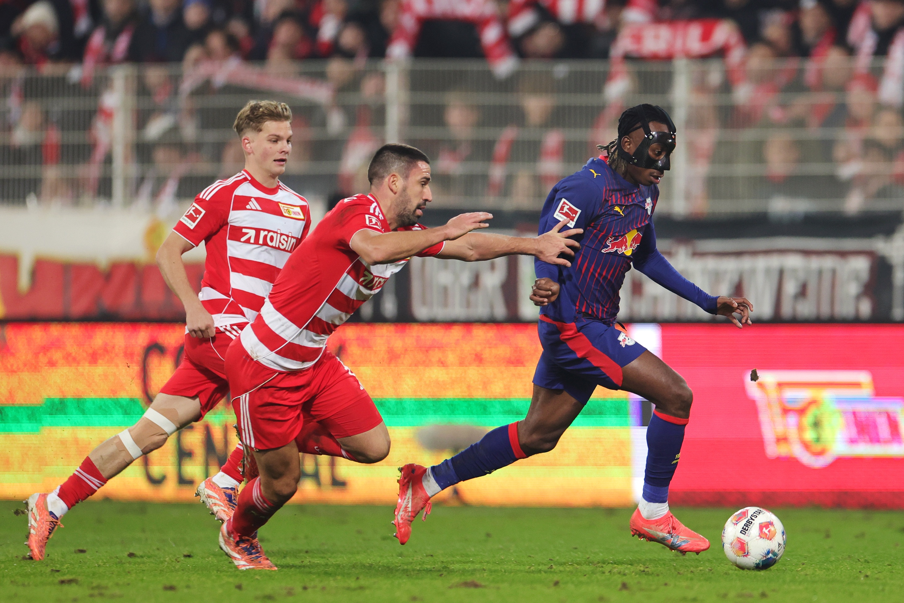 Jan Diomande dribbles with the ball past two Union Berlin players.