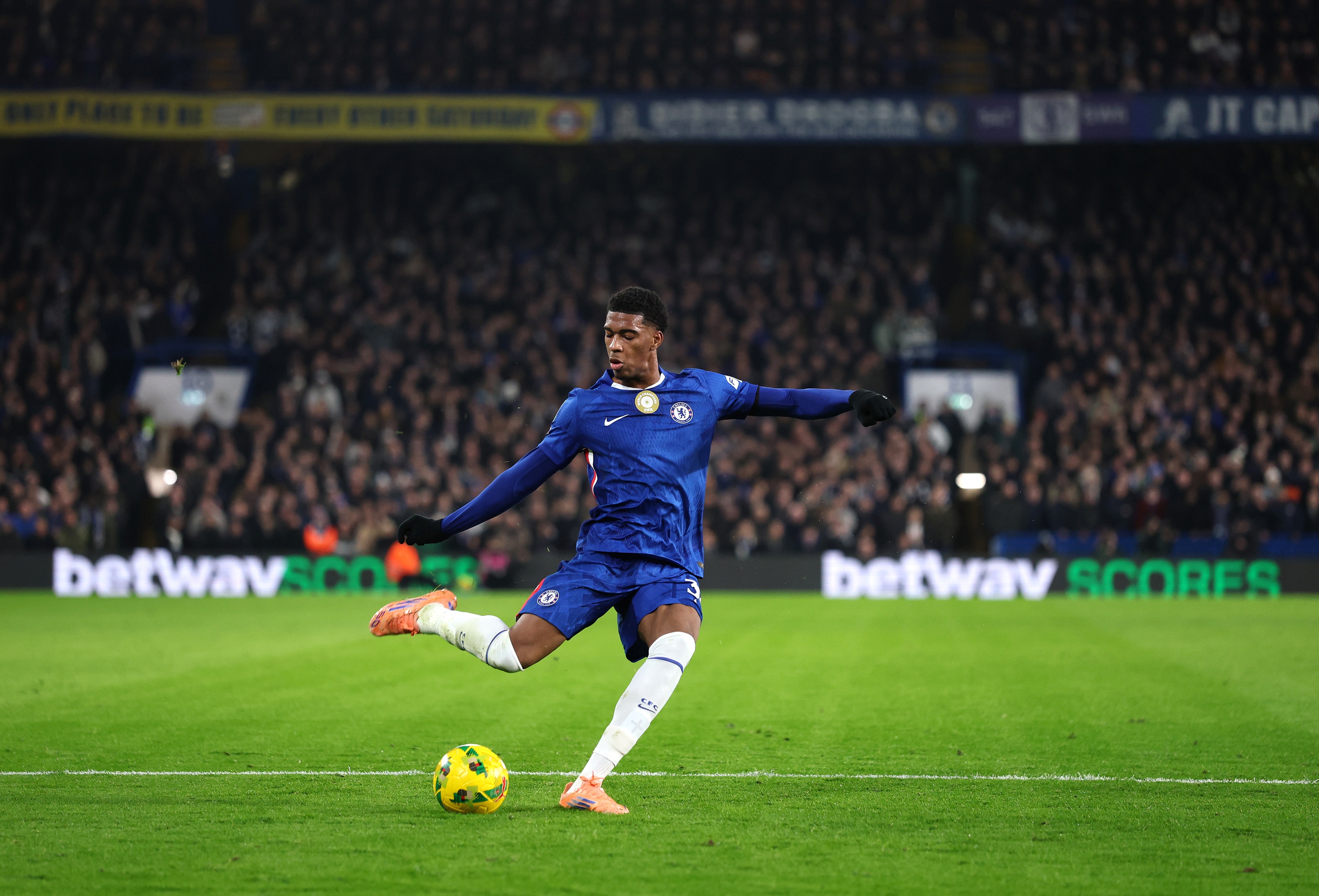 Josh Acheampong lifts his leg to play a pass.
