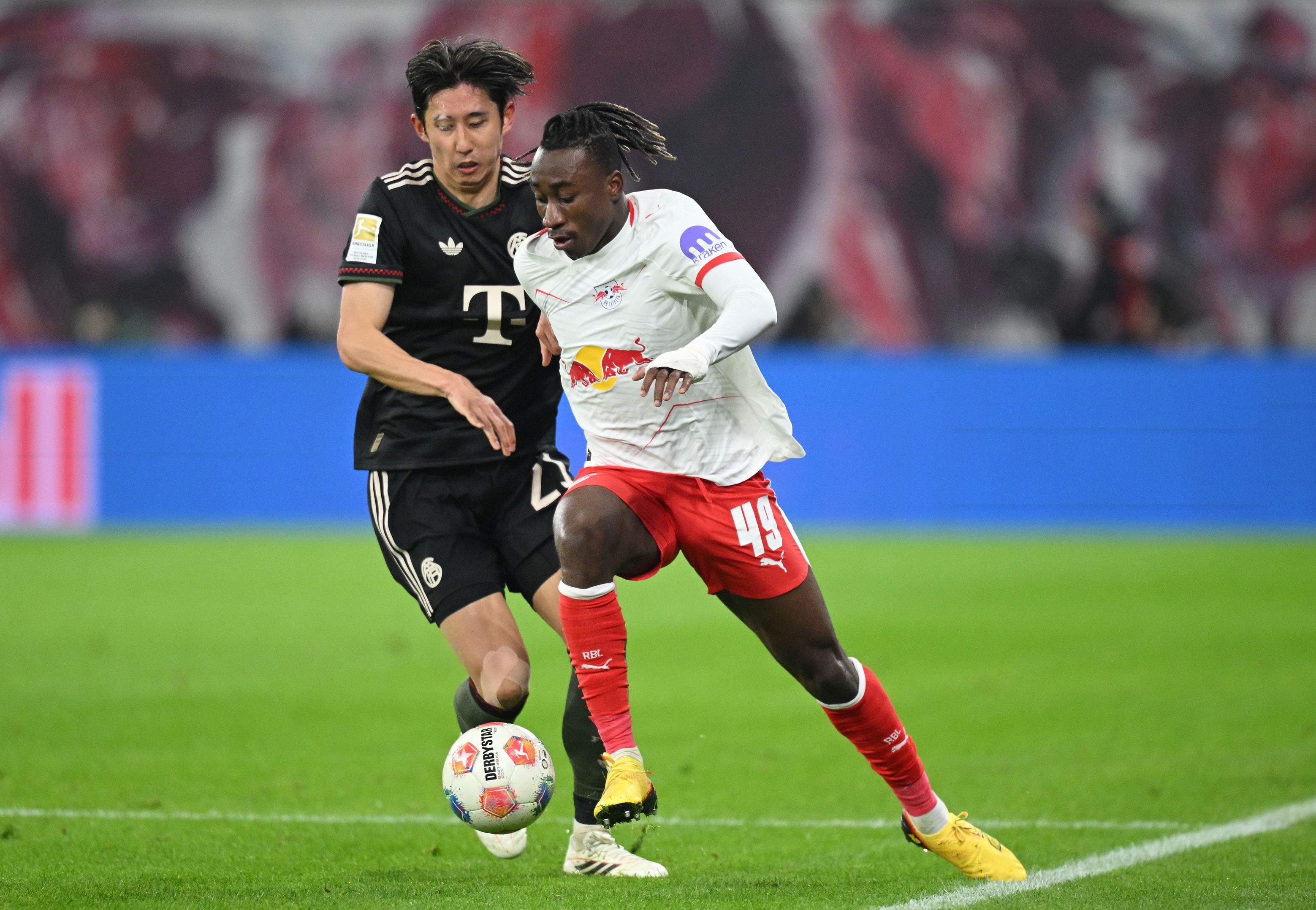 Yan Diomande dribbles past Hiroki Ito.