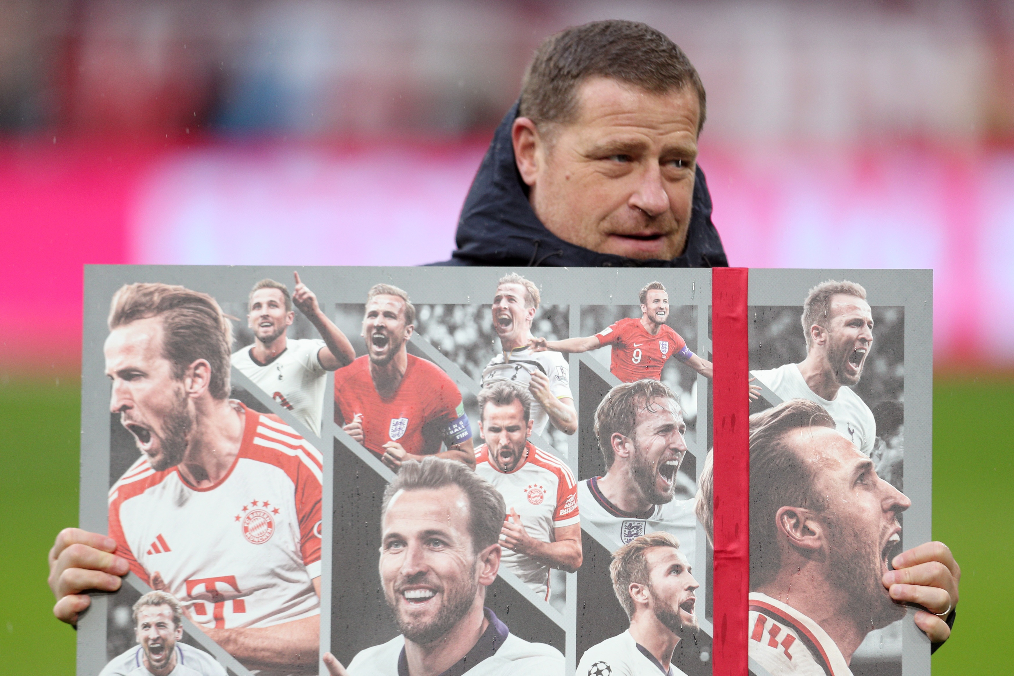 Max Eberl holds up photo card of Harry Kane.