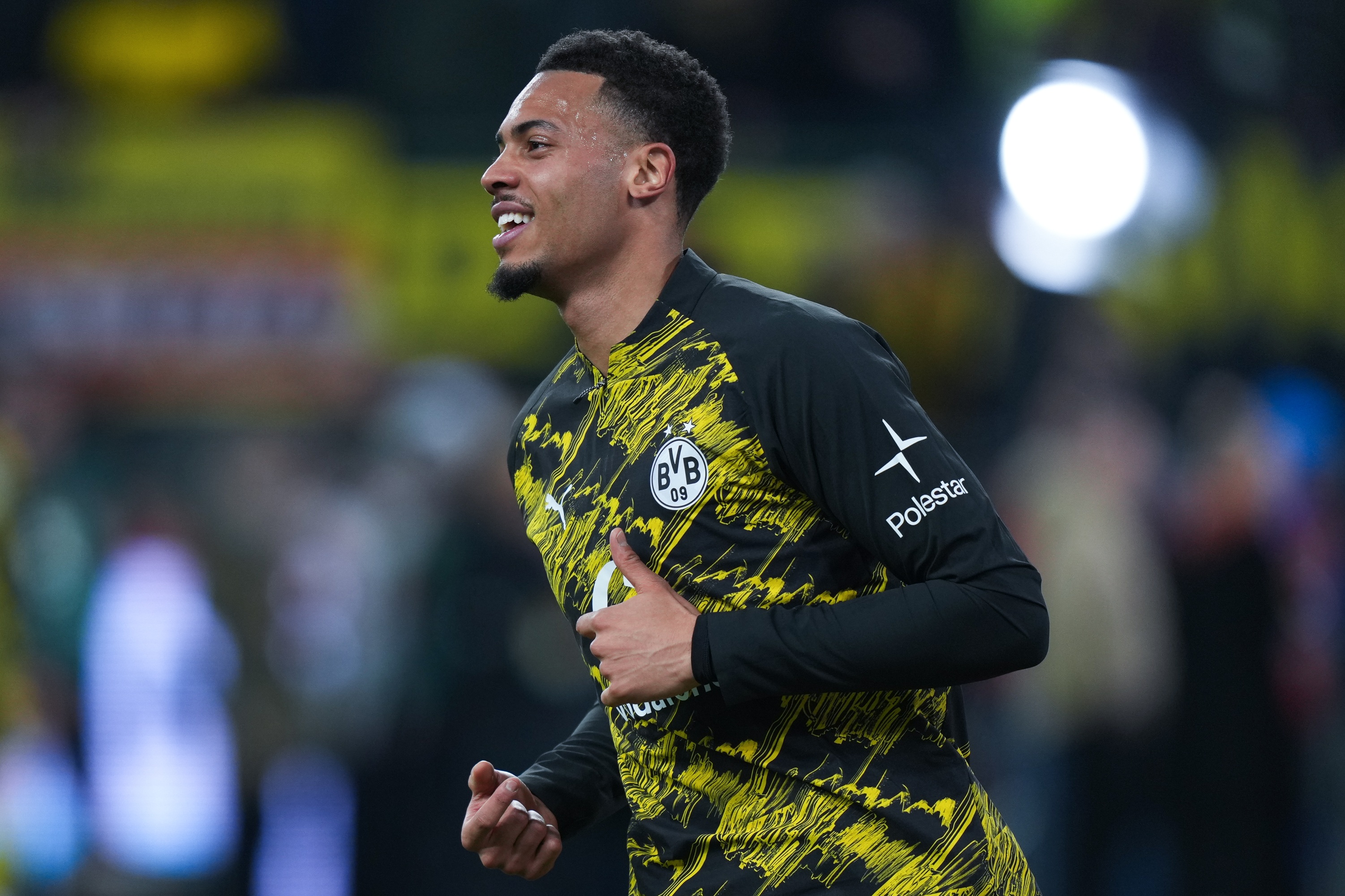 Felix Nmecha jogs on the pitch for Borussia Dortmund.