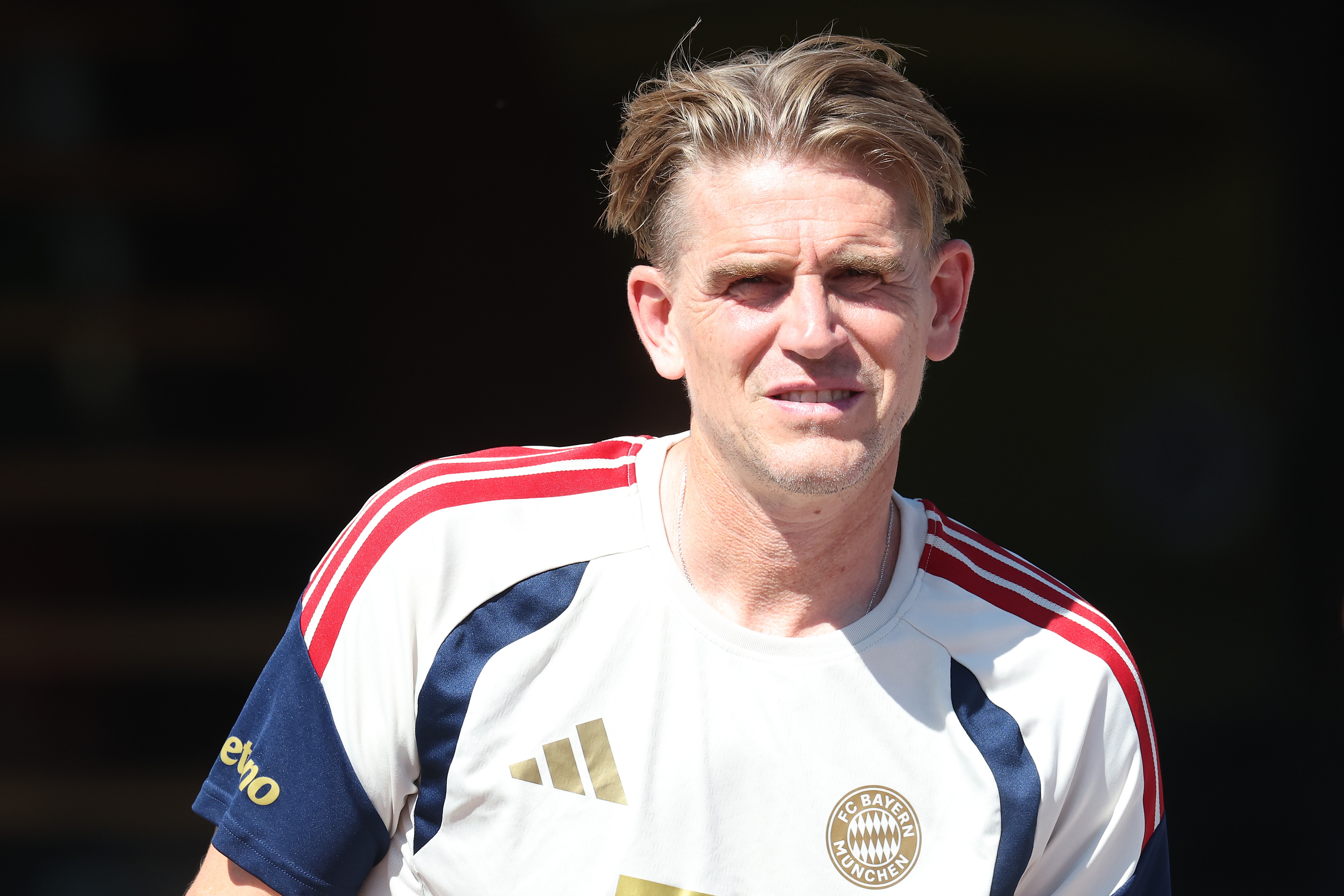 Bayern sporting director Christoph Freund squints through sunlight.