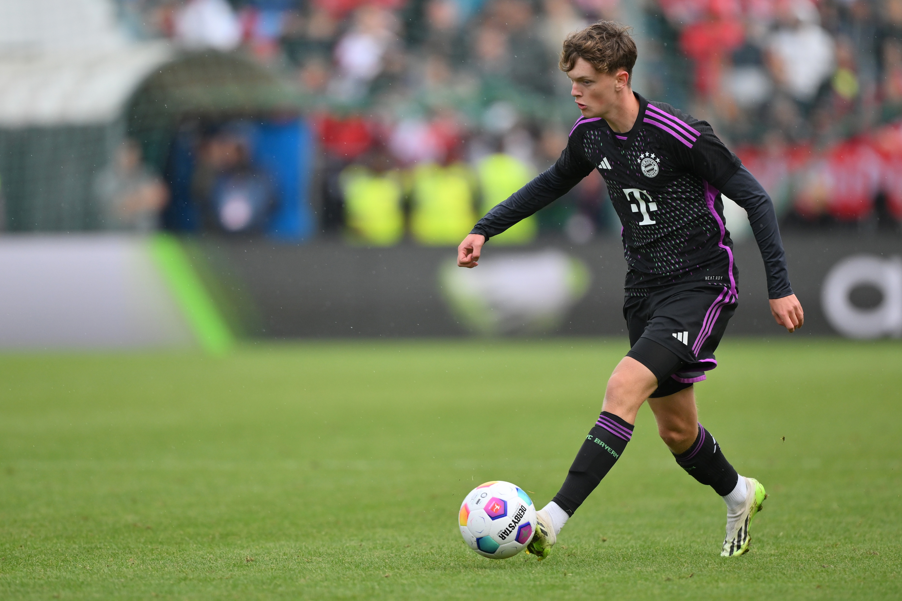 Paul Wanner dribbles with the ball during a Bayern Munich game.