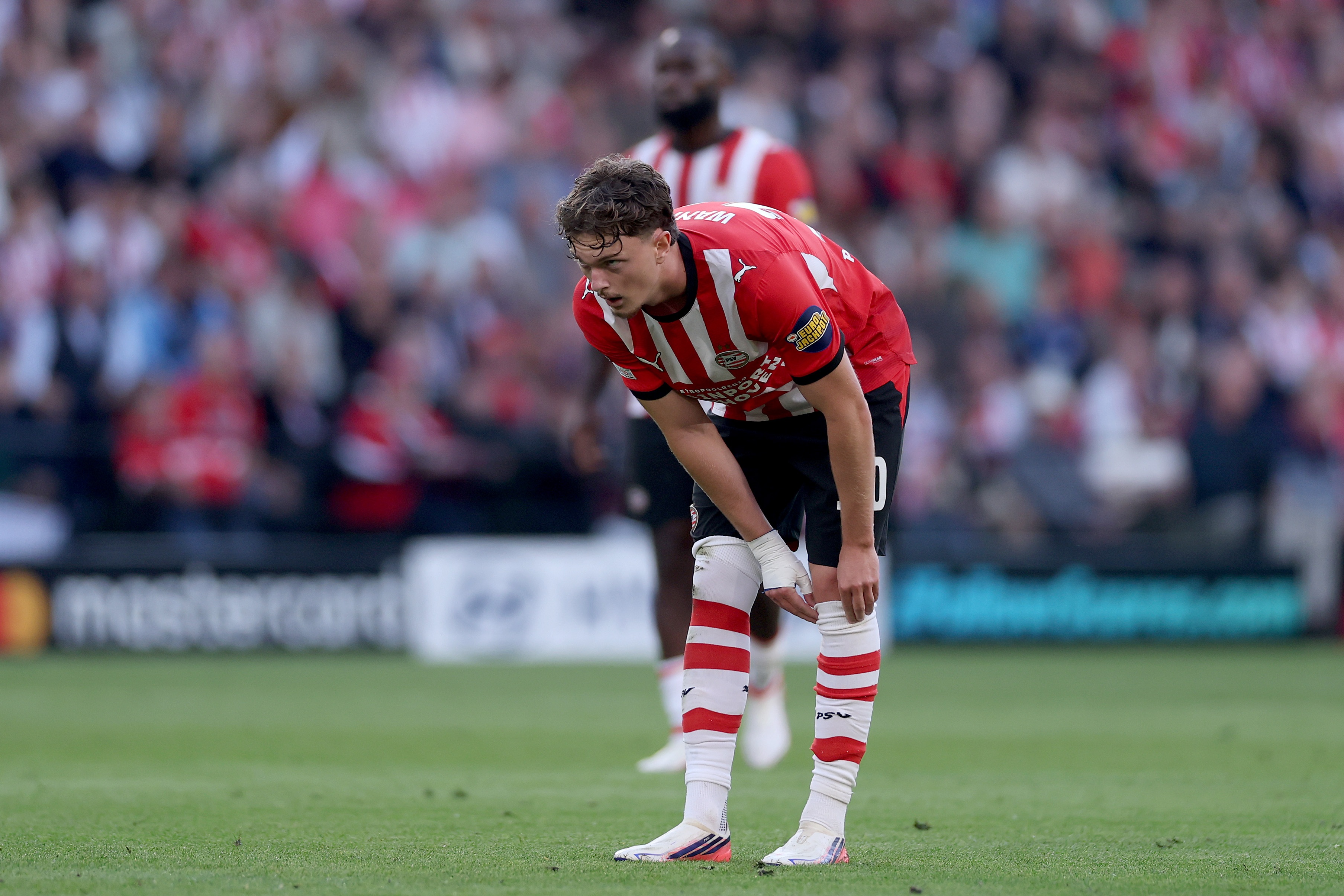 PSV midfielder Paul Wanner bends over to adjust one of his socks.