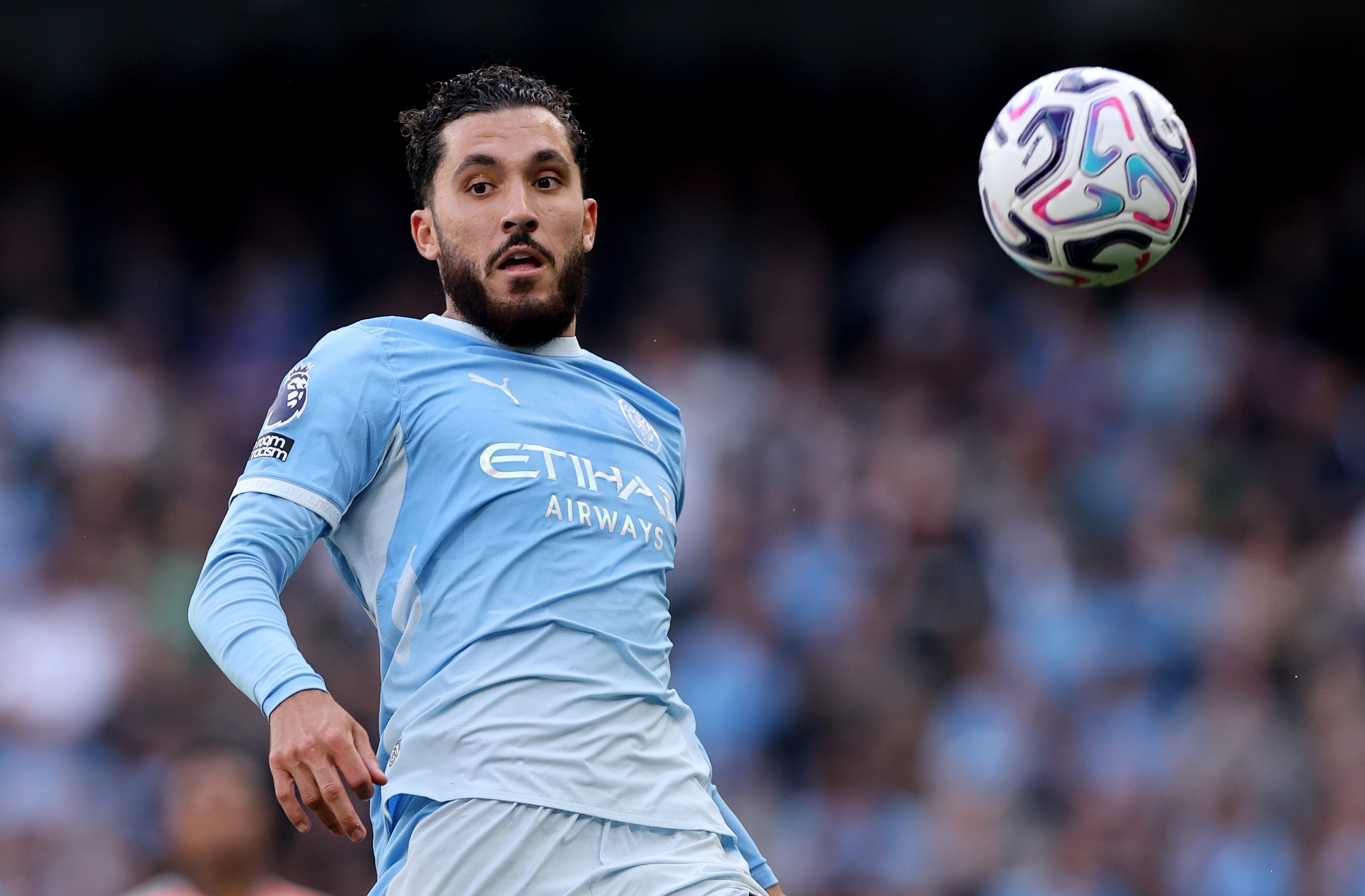 Rayan Cherki prepares to receive an airborne ball during a Man City game.