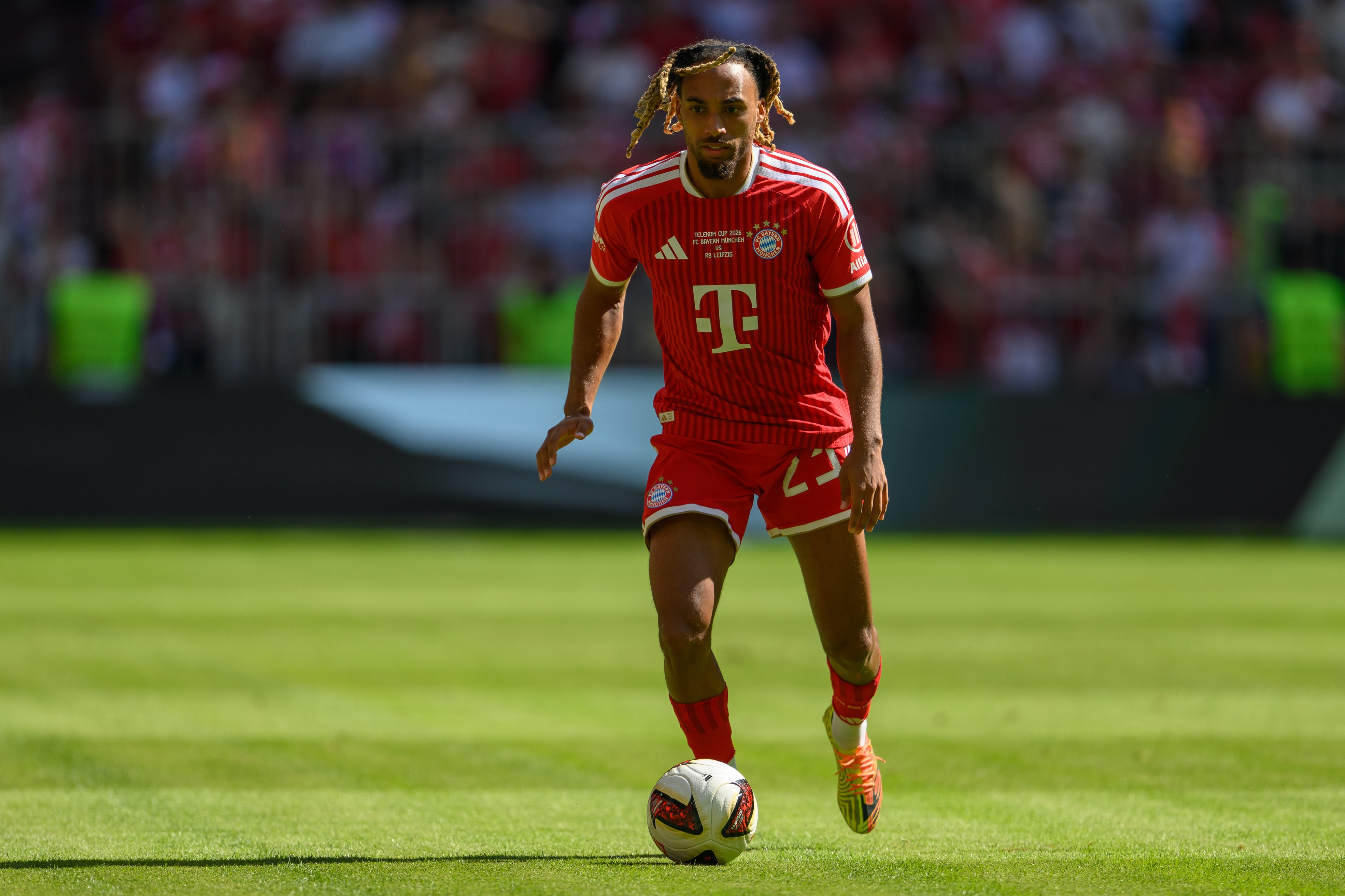 Bayern Munich fullback Sacha Boey dribbles with the ball.