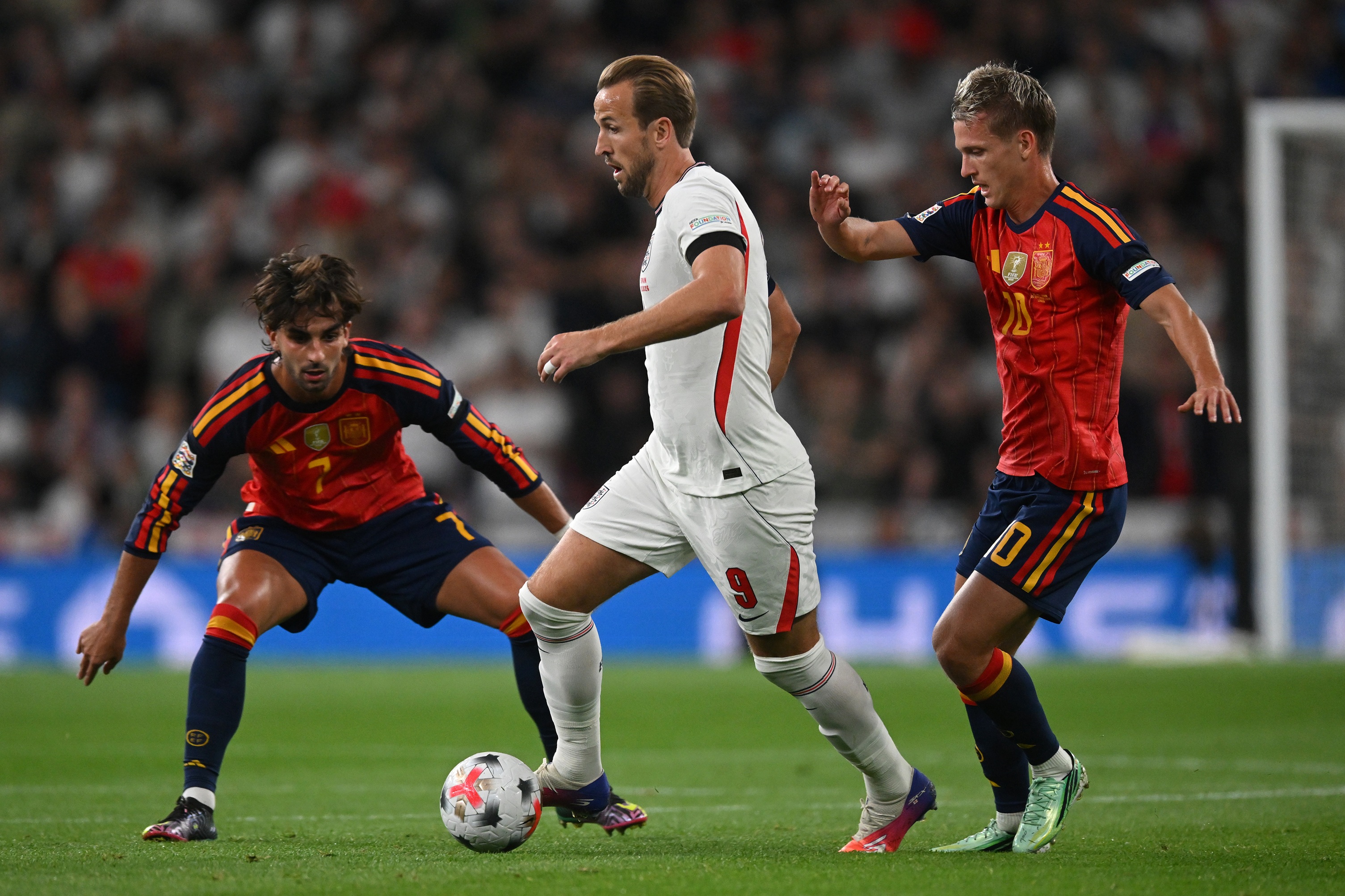 Barcelona attacker Dani Olmo puts pressure on Bayern Munich striker Harry Kane.