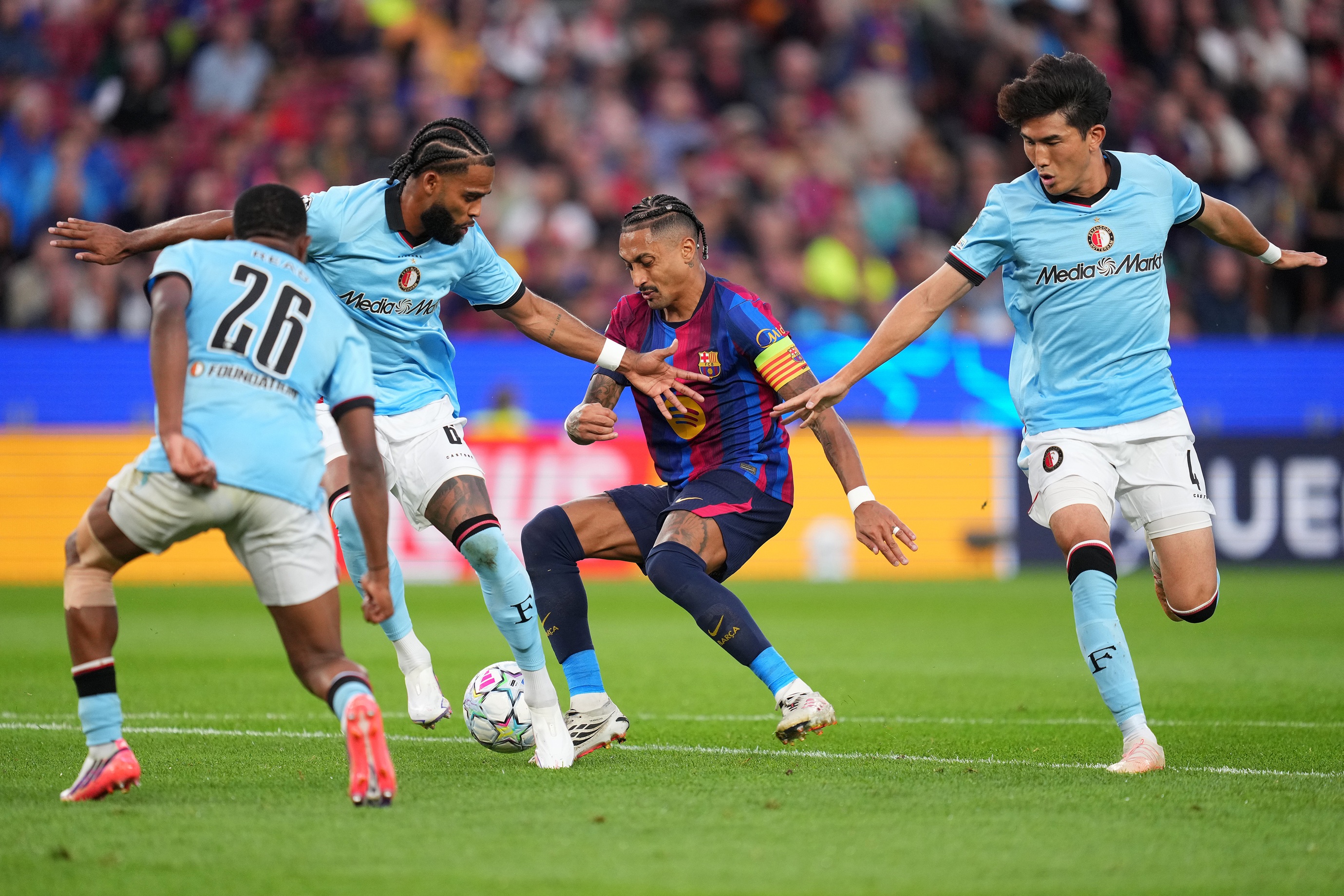 Feyenoord right-back Givairo Read challenges Barcelona attacker Raphinha.
