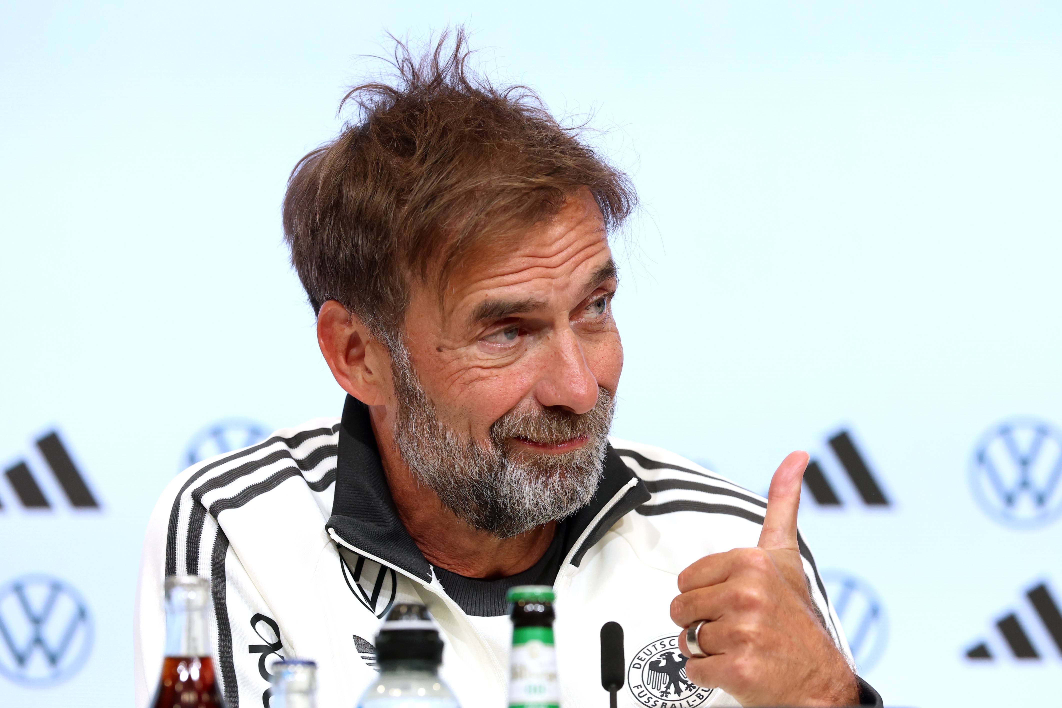 Germany manager Jurgen Klopp gives a thumbs up hand gesture and smiles during press conference.